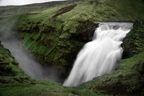 Bella cascata liscia in Islanda circondata da verdi colline — Foto Stock