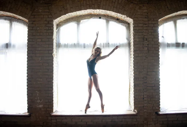 Silhueta de uma bailarina jovem de boa forma em pé na enorme janela. Conceito de saudável e beleza — Fotografia de Stock