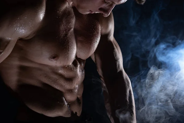 Homem musculoso mostrando músculos isolados em fundo preto. estilo de vida saudável — Fotografia de Stock