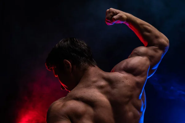 Muscular man showing muscles isolated on the black background close up. Concept of healthy lifestyle — Stock Photo, Image