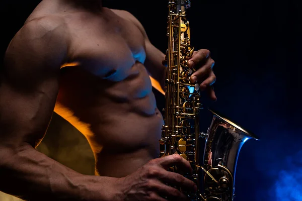 筋肉男とともに裸胴遊び上のサックスとともに喫煙カラフルな背景 — ストック写真