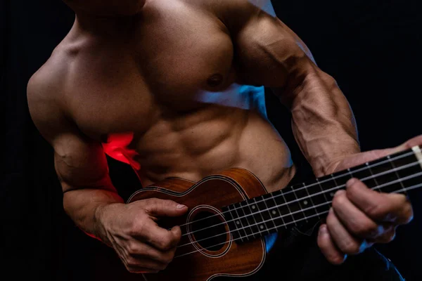 Homem muscular com tronco nu com ukulele e fumado fundo colorido — Fotografia de Stock