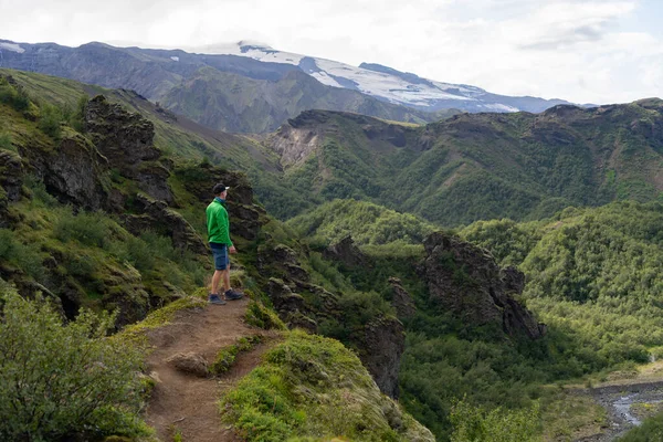 Hombre excursionista en la cima de una montaña verde — Foto de Stock