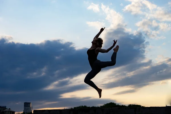 Bailarina joven sobre fondo de salida del sol al aire libre. Concepto de libertad y estilo de vida feliz — Foto de Stock