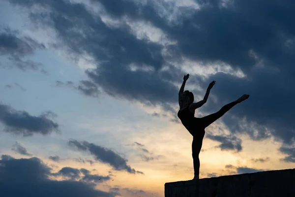 Bailarina joven sobre fondo de salida del sol al aire libre. Concepto de libertad, estilo de vida valiente y feliz — Foto de Stock