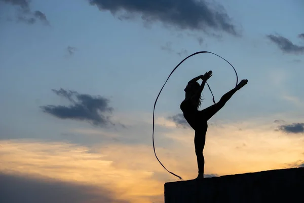 Bailarina profesional de gimnasta con cinta en el fondo del cielo — Foto de Stock