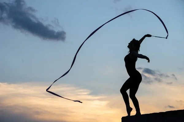 Bailarina profesional de gimnasta con cinta en el fondo del cielo — Foto de Stock