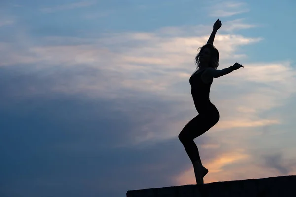 Bailarina mujer bien formada sobre fondo de salida del sol al aire libre. Concepto de libertad y estilo de vida feliz — Foto de Stock