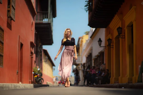 Hermosa mujer con vestido largo caminando sola por las coloridas calles de la ciudad amurallada colonial de Cartagena. Colombia — Foto de Stock