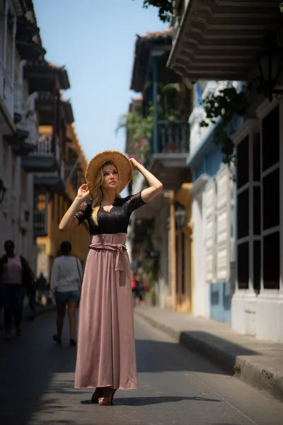 Hermosa mujer con vestido largo caminando sola por las coloridas calles de la ciudad amurallada colonial de Cartagena. Colombia — Foto de Stock