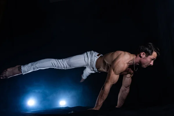 Gespierde man maken planche op zwart zwart achtergrond — Stockfoto