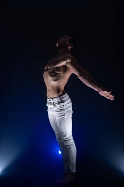 Siyah arka planda izole olmuş kasları gösteren kaslı bir adam. Amaç kavramı, kendi benliğinizi yaratmak, azim, metanet, odaklanma ve emek.