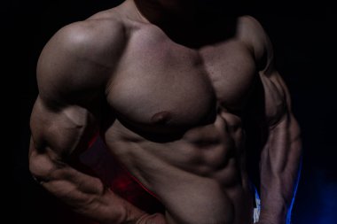 Siyah arka planda izole olmuş kasları gösteren kaslı bir adam. Amaç kavramı, kendi benliğinizi yaratmak, azim, metanet, odaklanma ve emek.