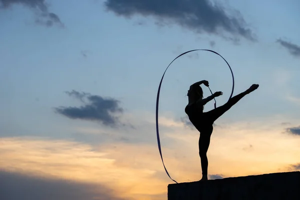 Bailarina profesional de gimnasta con cinta en el fondo del cielo — Foto de Stock