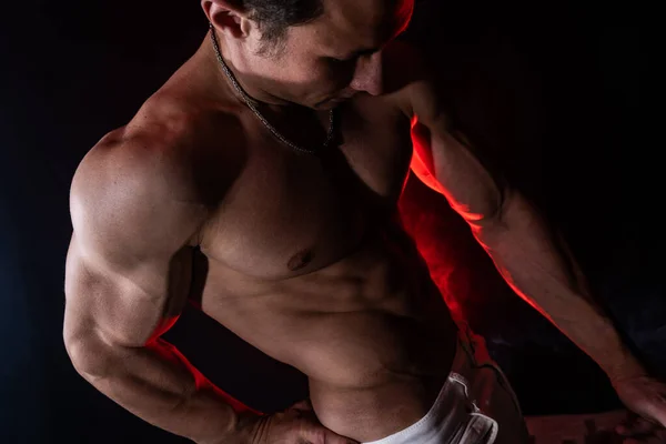 Hombre musculoso mostrando músculos aislados en el fondo negro. Concepto de meta, permite, crea tu ser, perseverancia, fortaleza, enfoque y trabajo — Foto de Stock