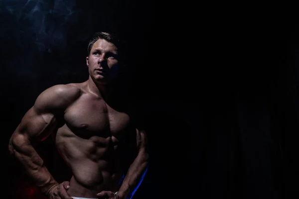 Gespierde man met spieren geïsoleerd op de zwarte achtergrond. Concept van bodybuilding en het creëren van uw lichaam in de sportschool — Stockfoto