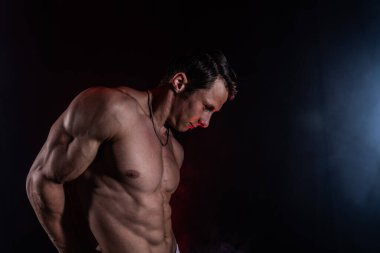 Siyah arka planda izole olmuş kasları gösteren kaslı bir adam. Amaç kavramı, kendi benliğinizi yaratmak, azim, metanet, odaklanma ve emek.