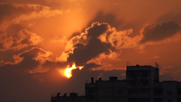 Silueta urbana con una espectacular puesta de sol nubes naranjas y disco solar — Vídeo de stock