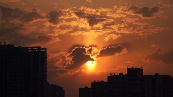 劇的な夕日オレンジの雲と太陽のディスクと都市のシルエット — ストック動画