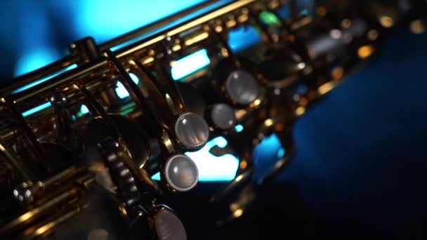 Saxophone alto brillant doré sur fond noir avec fumée bleue — Video