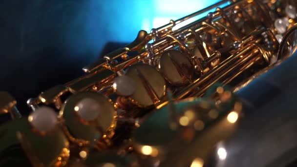 Saxophone alto emas mengkilap dengan asap biru. Konsep kasih karunia dan keanggunan — Stok Video