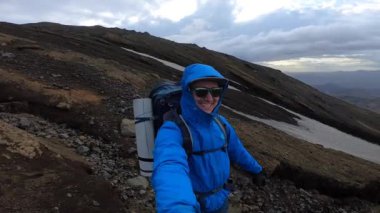 İzlanda 'daki genç yürüyüşçü Fimmvorduhals' ın yürüyüş parkurundaki buzulu işaret ediyor.