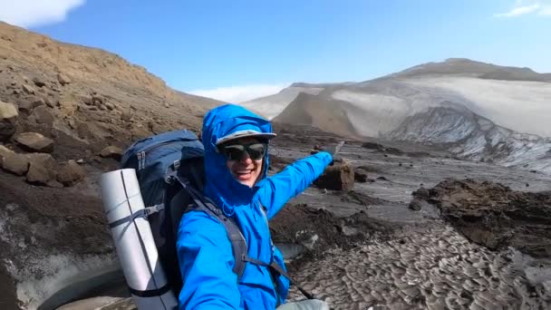 Joven excursionista en Islandia señalando el glaciar en la ruta de senderismo Fimmvorduhals — Vídeo de stock