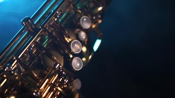 Złoty błyszczący saksofon altowy z niebieskim dymem. Pojęcie łaski i elegancji — Wideo stockowe