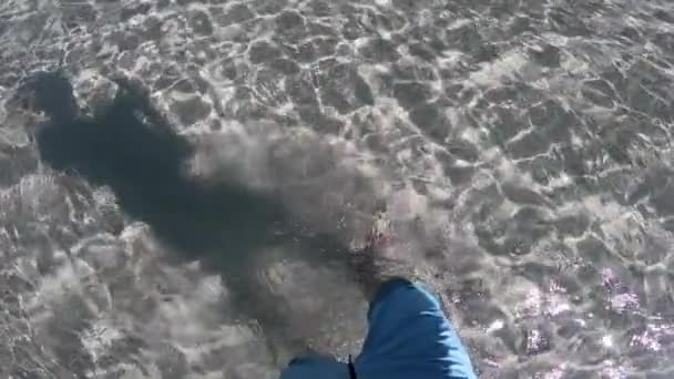 Pies Masculinos caminando en la arena de playa de agua de mar de cristal poco profundo. Concepto de relax y felicidad . — Vídeos de Stock