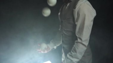 Takım elbiseli bir işadamı beyaz toplarla hokkabazlık yapıyor. Başarı ve yönetim