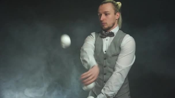 Un hombre de negocios con un traje haciendo malabares con bolas blancas. Éxito y gestión — Vídeos de Stock