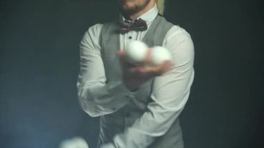 Takım elbiseli bir işadamı beyaz toplarla hokkabazlık yapıyor. Başarı ve yönetim