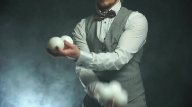 Beyaz toplarla hokkabazlık yapan takım elbiseli eller. Başarı ve yönetim