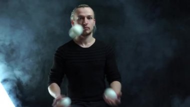 Siyah bir jonglör ve beyaz toplar takan bir adam. Yönetim, kontrol ve başarı