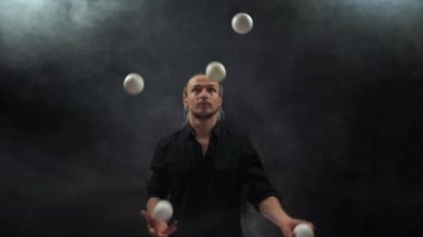 Siyah bir jonglör ve beyaz toplar takan bir adam. Yönetim, kontrol ve başarı