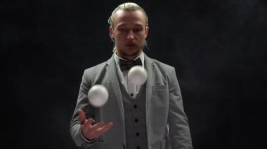 Takım elbiseli bir iş adamı beyaz toplarla hokkabazlık yapıyor. Sonunda mutsuz duygular. Gevşeme kavramı 