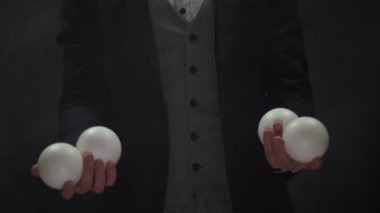 Beyaz toplarla hokkabazlık yapan takım elbiseli eller. Başarı ve yönetim