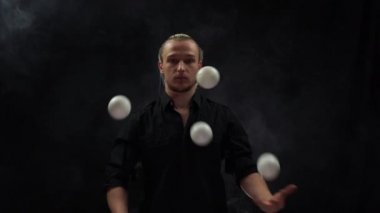 Siyah bir jonglör ve beyaz toplar takan bir adam. Yönetim, kontrol ve başarı