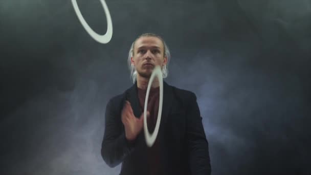 Man wearing a black juggling with white rings. Management, control and success — Stock Video
