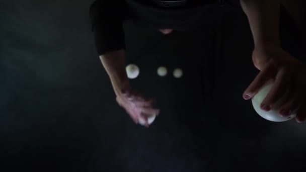 Artista de circo usando malabarismo preto com bolas brancas . — Vídeo de Stock