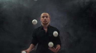 Siyah bir jonglör ve beyaz toplar takan bir adam. Yönetim, kontrol ve başarı