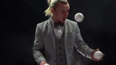 Takım elbiseli bir iş adamı beyaz toplarla hokkabazlık yapıyor. Sonunda mutlu bir duygu. Başarı ve yönetim kavramı