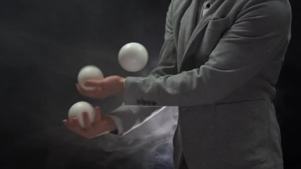 Крупный план рук в костюме жонглирующих белыми шариками. Успех и управление — стоковое видео