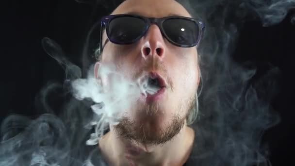 Man vaping big ring of steam and sends it to the camera with in slow motion — Stock Video