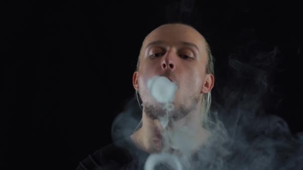 Man vaping big ring of steam and sends it to the camera with in slow motion — Stock Video