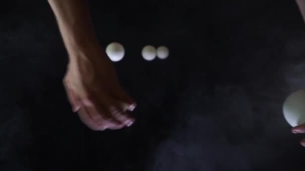 Cirkus umělec na sobě černé žonglování s bílými kuličkami ve zpomaleném filmu — Stock video