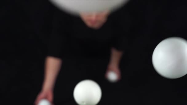 Artiste de cirque portant jonglerie noire avec des boules blanches au ralenti — Video