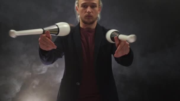 Mann in Schwarz jongliert mit Knüppeln. Management, Kontrolle und Erfolg — Stockvideo