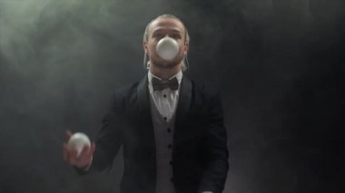 Takım elbiseli bir işadamı beyaz toplarla hokkabazlık yapıyor. Başarı ve yönetim