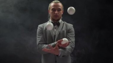 Takım elbiseli bir işadamı beyaz toplarla hokkabazlık yapıyor. Başarı ve yönetim